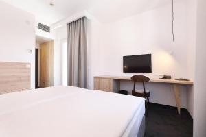 a bedroom with a bed and a desk with a television at Hotel Mediteran in Zadar