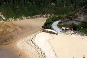 una vista aérea de una playa con gente en la arena en CHALETS PLAYA GALIZANO, en Galizano