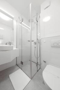 a bathroom with a shower and a toilet and a sink at Hotel Mediteran in Zadar