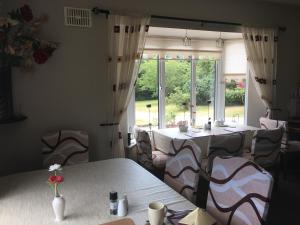 a restaurant with tables and chairs and a large window at Killurin Lodge in Wexford