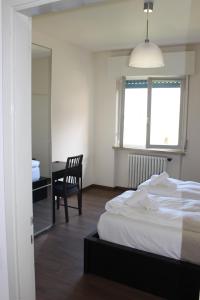 una camera da letto con un letto, una sedia e una finestra di Casa Ines Fronte Lago a Brenzone sul Garda