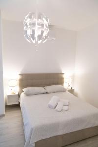 biała sypialnia z dużym łóżkiem i 2 ręcznikami w obiekcie Casa Anna by Home080 - Puglia Mia Apartments w mieście Monopoli