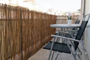 a table and chairs in front of a wooden fence at Comfy Apartment With Acropolis View in Athens