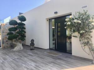 una puerta delantera de un edificio con dos árboles en Villa Carlota, en Villajoyosa