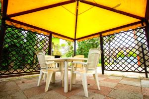 リド・ディリ・スカッキにあるAgenzia Vear - Villa Serenaの黄色い傘下のテーブルと椅子