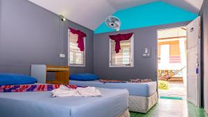 Cette chambre dispose de 3 lits et d'un plafond bleu. dans l'établissement Sun Beach Bungalows, à Haad Rin