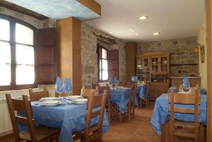 a dining room with blue tables and wooden chairs at El Cuartelillo Viejo in Polientes