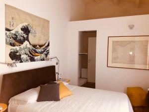 a bedroom with a painting on the wall at B&B Mare di Fuori in Stintino