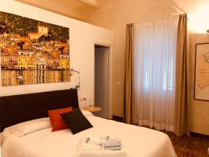 a bedroom with a bed with a painting on the wall at B&B Mare di Fuori in Stintino