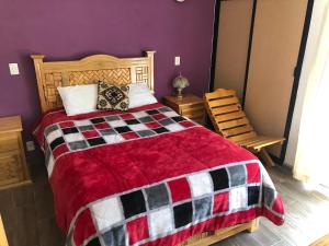 a bedroom with a bed with a red and black blanket at San Jose Olympia in San Crist&oacute;bal de Las Casas