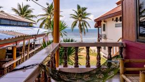 a hammock on the balcony of a house overlooking the ocean at Sun Beach Bungalows resort in Haad Rin