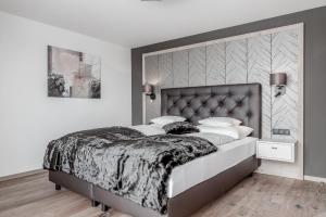 1 dormitorio con 1 cama grande y cabecero grande en Hotel Enzian Hochsölden Superior, en Sölden