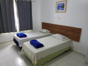 two beds with blue pillows in a room at HOTEL FLUMINENSE in Gandu