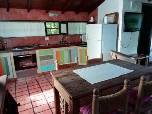 cocina con mesa de madera y nevera en Petua en Mar del Plata