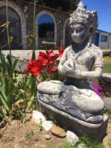 a statue of a woman sitting in a stone bowl at Conviento de Lobos in Pichilemu