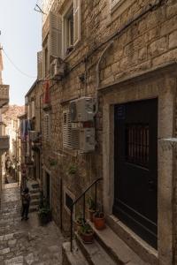 a person walking down an alley with a building at Guest House Tomasi One in Dubrovnik