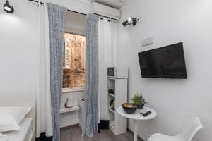 Zimmer mit einem kleinen Tisch und einem TV an der Wand in der Unterkunft Guest House Tomasi One in Dubrovnik