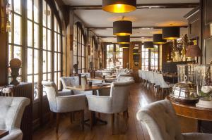 a restaurant with tables and chairs and windows at Hotel de la Poste - Relais de Napoleon III in Bouillon +38 photos
