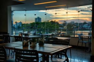 a restaurant with tables and chairs and a view of the city at Hotel Atlas in Sete Lagoas