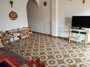 a living room with a table and a tv at Palazzo Ionio in Scalea