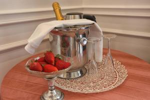 a bowl of strawberries sitting on a table with a bucket at Promenade Maison de Charme in Sanremo