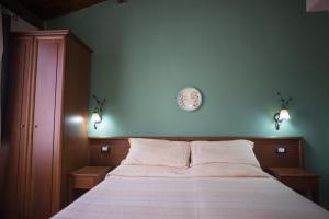 ein Schlafzimmer mit einem Bett mit einer Uhr an der Wand in der Unterkunft B&B Salotto Di Athena in Agrigento