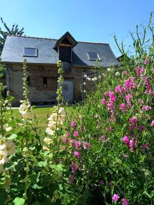 an old barn with pink flowers in front of it at Arrest-en-Baie in Arrest
