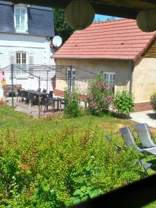 a house with a table and chairs in a yard at Arrest-en-Baie in Arrest