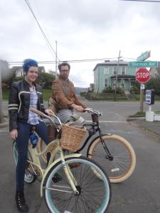 a man and a woman standing next to a bike at Itty Bitty Inn in North Bend