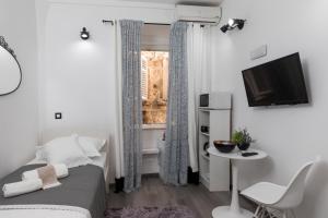 Kleines weißes Zimmer mit einem Bett und einem TV. in der Unterkunft Guest House Tomasi One in Dubrovnik