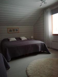 a bedroom with a bed and a window and a rug at Topin Tupa 1 in Oravisalo