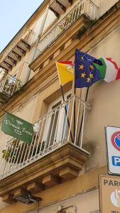 two flags on a balcony of a building at B&B Domus Enna in Enna