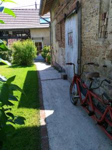 una bicicleta roja estacionada junto a un edificio de ladrillo en Arrest-en-Baie en Arrest