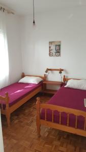 twee bedden naast elkaar in een kamer bij Apartmants Katica in Novalja