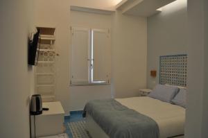 a small bedroom with a bed and a window at B&B FISH in Vietri sul Mare