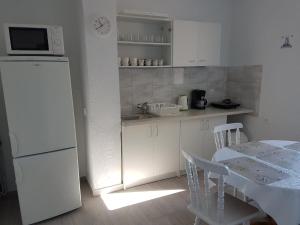 a kitchen with a table and a white refrigerator at Marynarska 19 in Darłówko