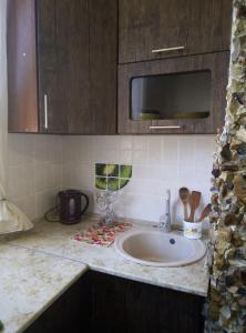 un bancone della cucina con lavello e forno a microonde di Апартаменты на Агрба 11/1 a Pizunda