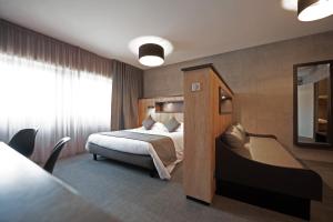 a hotel room with a bed and a table at Nota Bene in Montceau-les-Mines