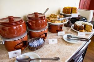 a table with jars of cake and other desserts at Pousada Solar da Lapa in Lapa