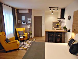 een kamer met een bed en 2 stoelen en een keuken bij Apartments Glam in Poreč