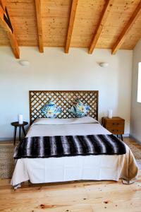 a bedroom with a large bed in a room with wooden ceilings at Casa do Cais da Torreira in Torreira
