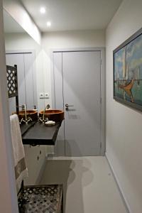 a bathroom with a walk in shower and a sink at Casa do Cais da Torreira in Torreira