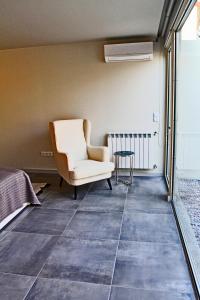 a living room with a chair and a table at Casa do Cais da Torreira in Torreira