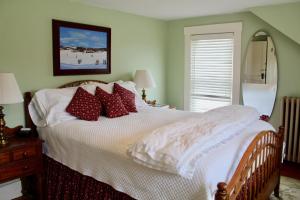 a bedroom with a white bed with red pillows at Sugar Hill Inn in Sugar Hill