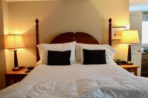 a bedroom with a large white bed with two lamps at Sugar Hill Inn in Sugar Hill