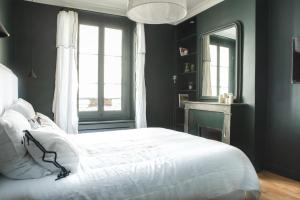 a bedroom with a white bed and a window at Dreamyflat - Montmartre ll in Paris