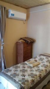 a bedroom with a bed and a wooden dresser with a bed sqor at El patio de marta in Posadas