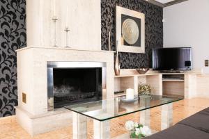 a living room with a fireplace and a glass table at Villa Bo in Deltebre
