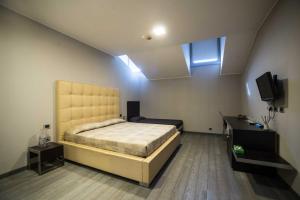 1 dormitorio con 1 cama y TV en Blue Hotel, en Suzzara