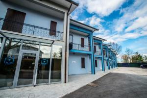 a row of blue buildings with glass doors at Blue Hotel in Suzzara